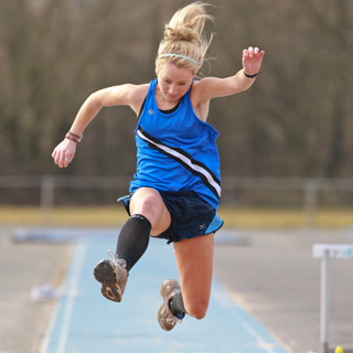 Photo of woman jumping hurdle
