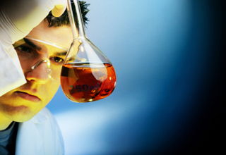 A man examines a beaker of liquid