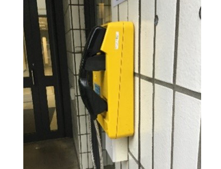 Yellow telephone on the wall on the Library by the staff entrance