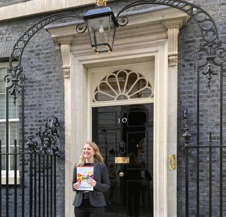 Charlotte hoding paper folder in front of No.10 Downing Street