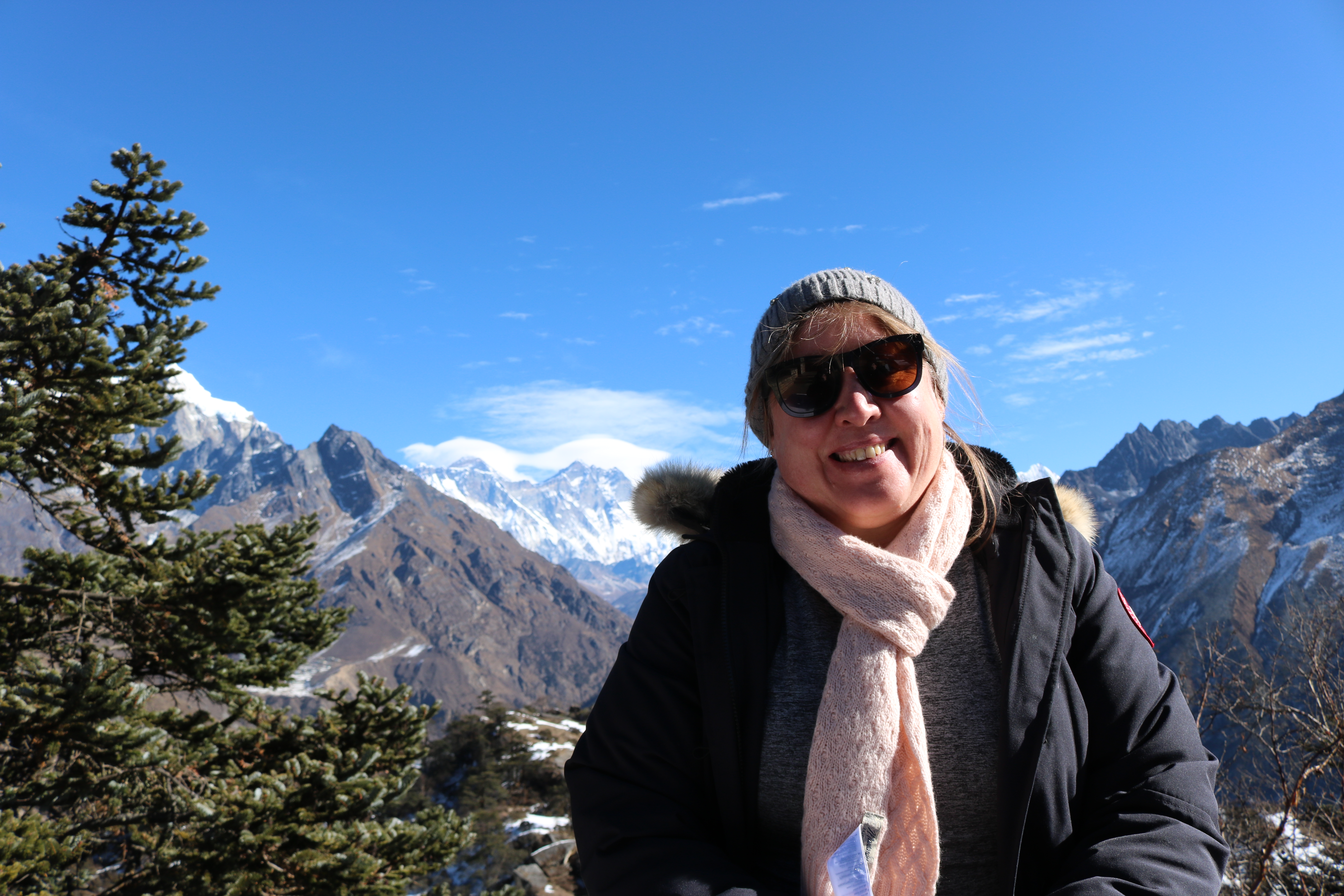 Lisa standing in front of a snowy mountain vally